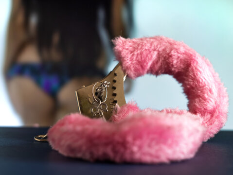 Fluffy Pink Handcuffs on Table with Model