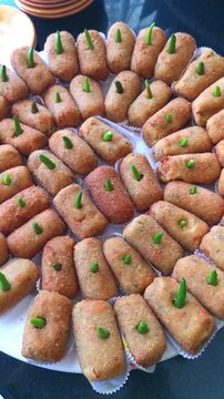 Vertical video zoom out of traditional Indonesian risoles rissoles platter garnished with green chili peppers