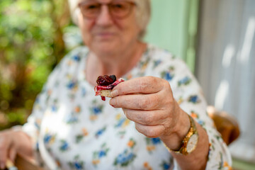 Elderly woman offering berry treat. © Rawpixel.com