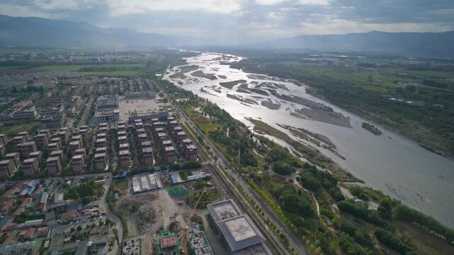 Early Morning High-Angle Aerial View of Tekes River and Bagua City in Ili: Morning Sunbeams Crepuscular Rays, Dawn Cloudscape, Mountain Range and Wetland Landscape in Xinjiang