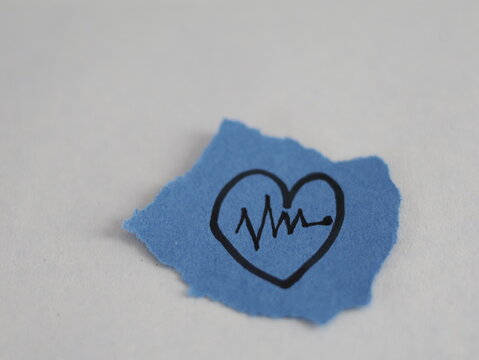 Un papel rasgado con una linea negra con forma de corazon con una linea con forma de ritmo cardiaco en un fondo blanco 