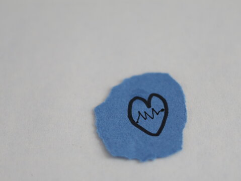 Un papel rasgado con una linea negra con forma de corazon con una linea con forma de ritmo cardiaco en un fondo blanco 