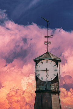 Clock tower of Oslo City Hall against a dramatic pink sunset sky.