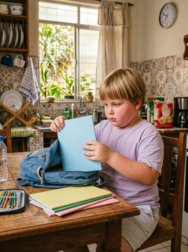 Boy packing notebooks for school