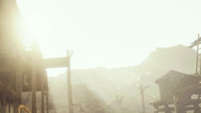 Sunlight shines over a small village with dusty streets and simple wooden buildings. Mountains rise in the background as evening sets in, creating a soft glow in the sky.