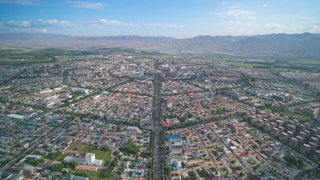 High-Angle Aerial Panoramic View of Tekes Bagua City in Ili: Unique Bagua I-Ching Geometric Layout, Radial Streets, Circular Ring Roads, Blue Sky and Mountain Range in Xinjiang