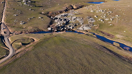 Fototapeta premium Aerial View of Rural Landscape with Granite Boulders and Winding Stream