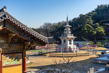 Obraz premium Stone pagoda surrounded by traditional Korean temple buildings at Ssanggyesa in Daebudo