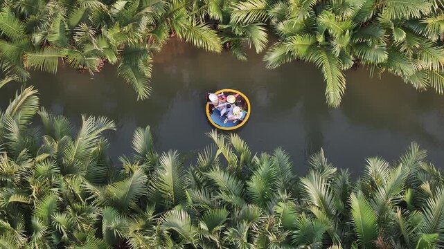 Aerial view of the natural scenery of basket boats on the Thu Bon River across palm trees in Hoi An Ancient Town, Vietnam
