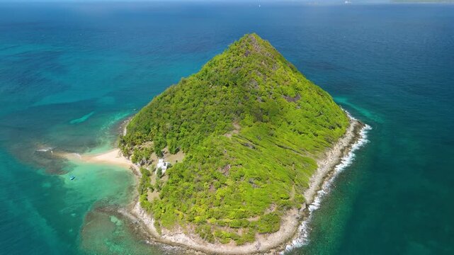 Aerial pullback from Sugar Loaf Island widens the scene of sandy beach and shallow reef near Carriacou and Grenadines