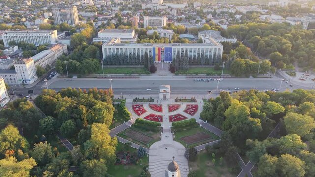 Aerial drone pull-back over central Chisinau, Moldova, revealing the Nativity Cathedral and bell tower, Cathedral Park, Great National Assembly Square and Government House.