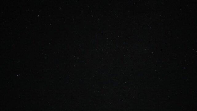 Timelapse video of stars moving across a dark night sky, revealing the subtle motion of the celestial landscape over time. A peaceful astronomy scene ideal for themes of space, stargazing, nighttime,