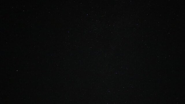 Timelapse video of stars moving across a dark night sky, revealing the subtle motion of the celestial landscape over time. A peaceful astronomy scene ideal for themes of space, stargazing, nighttime,