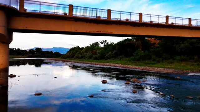 Flying under bridge over Colorado River during draught season, mid day, late summer.