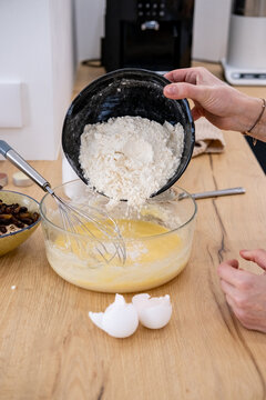 Cooking dough. Pouring flour. Female confectioner hand adding dry baking ingredient to bowl preparing meal tasty recipe at home kitchen.