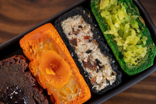 Colorful Vietnamese mooncake halves with assorted fillings on tray
