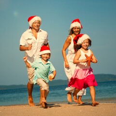 Naklejka premium Family enjoying a Christmas holiday at the beach