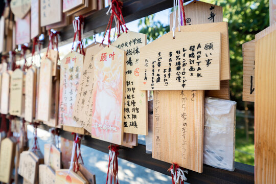 Close-up of wooden ema prayer plaques with Japanese handwritten wishes at Miyajidake Shrine, Fukuoka, Japan