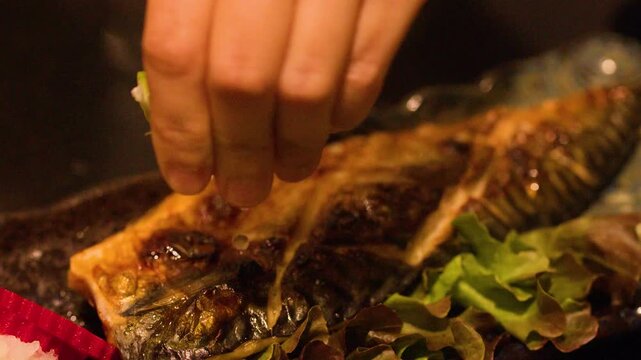 Squeezing Fresh Lime Juice onto Grilled Mackerel Saba Fish