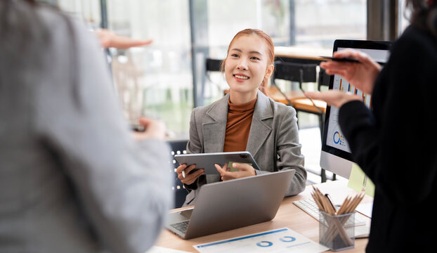 Asian Business Woman Smiling and Listening to Team Discussion in Office