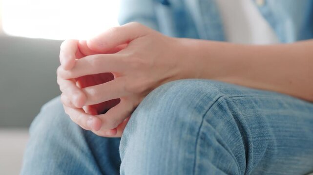 Closeup legs shaking in a guy in blue jeans. Uncontrollable leg shaking. Severe stress in a guy. A man is worried while sitting on a sofa. Health problems and sickness
