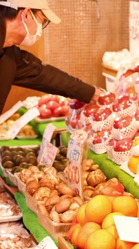 Customer Selecting Fresh Red Apples at a Tokyo Street Market
