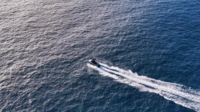 Aerial View of Motorboat Speeding Across Blue Ocean Water
