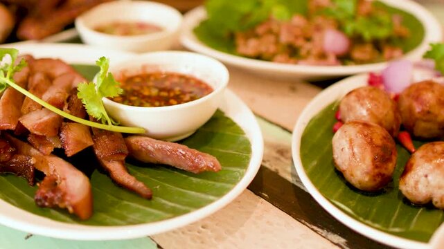 Grilled Pork Jowl and Thai Isan Sausages on Table