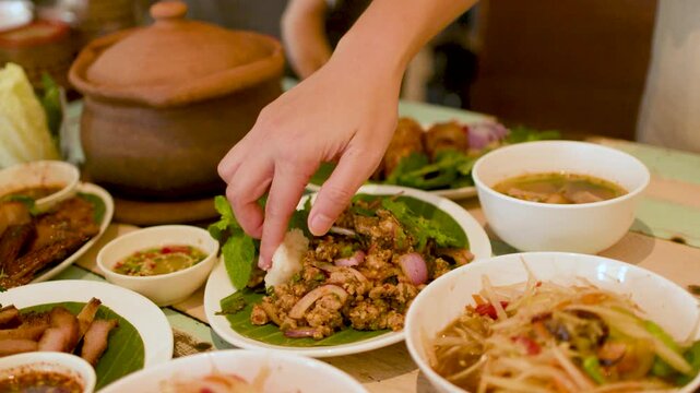 Person Eating Thai Isan Larb Moo Minced Pork Salad with Sticky Rice