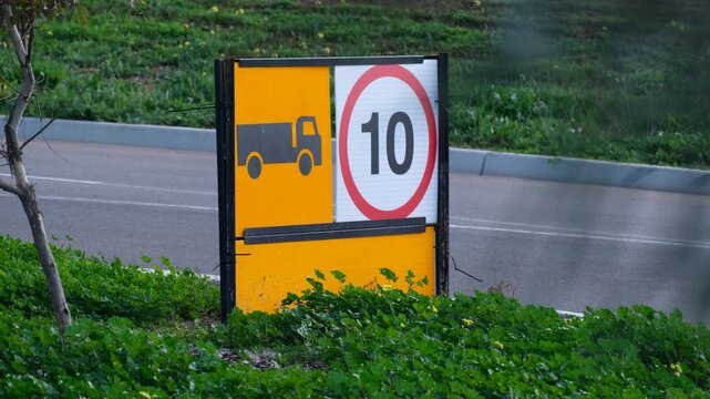 a site restriction sign with a truck symbol and a 10 km/h speed limit posted next to a road in Victoria, Australia. Controlling heavy vehicle and truck speeds on site