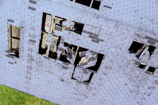 Damaged roof has several missing shingles openings, wear neglect at vacant site
