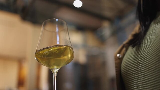 Low angle: White wine is swirled in angular wine glass to aerate it