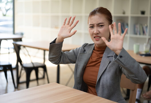Asian Businesswoman Showing Disgusted Face Making Stop Gesture With Hands In Office