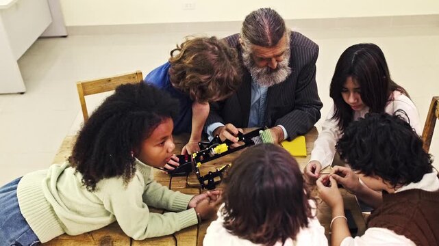 Students collaborate with a teacher to assemble a small robot, working with electronics and tools during a hands-on STEM workshop.