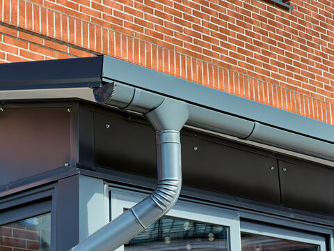 newly renovated old building facade with gutter and drainpipe.