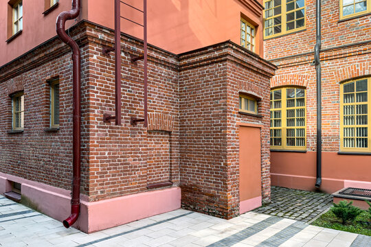 old factory building after renovation. corner of industrial building with installed metal rain drainpipe.