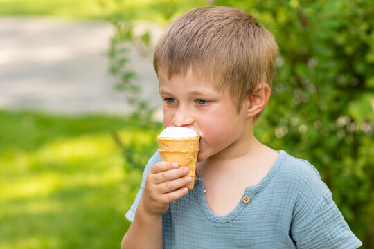 Young Boy Eating Vanilla Ice Cream in Park