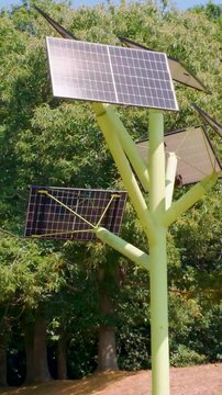 Multi-angle solar tree array post low orbit, its panels tilted to capture sunlight at Southampton Science Park, England. Vertical format for social media.