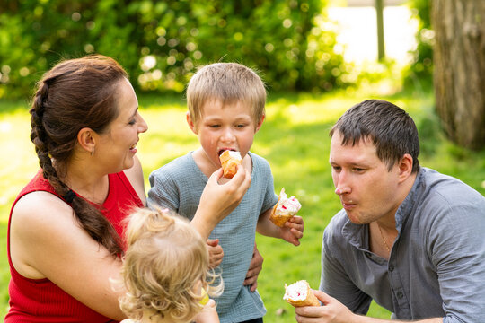 Family Enjoying Ice Cream Together in Sunny Park