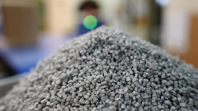 Macro close-up of gray rubber compound granules used in pencil eraser manufacturing