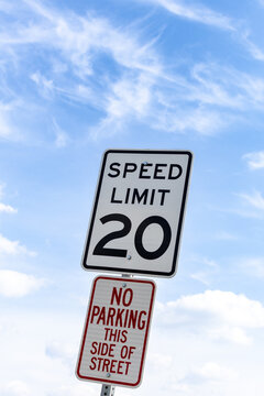 Speed limit sign indicating 20 miles per hour and no parking on this side of street in clear sky