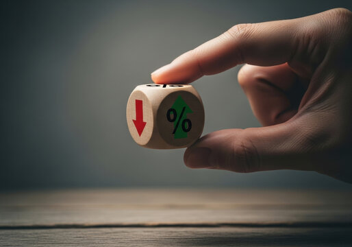 Close up of hand holding wooden dice showing green upward percent arrow and red downward arrow indicating financial volatility.