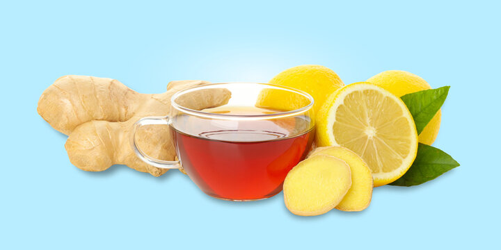 Cup of ginger tea accompanied by fresh lemons and ginger root