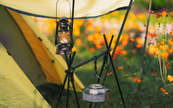 Camping lantern hanging from tent in a garden
