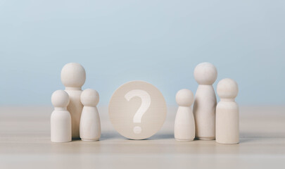Fototapeta na wymiar Wooden family figures surround a question mark, symbolizing uncertainty, family decisions, relationship choices, identity, support, communication, and important life choices in a calm setting.