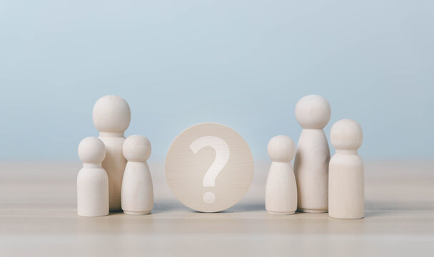 Wooden family figures surround a question mark, symbolizing uncertainty, family decisions, relationship choices, identity, support, communication, and important life choices in a calm setting.