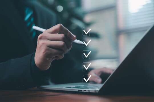 Business professional using a laptop and digital checklist to review tasks, verify information, track progress, and manage workflow, representing productivity, accuracy, compliance and decision making