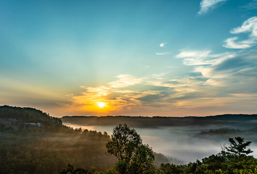 The sun rises above the misty valley of Red River Gorge in Daniel Boone National Forest, Kentucky