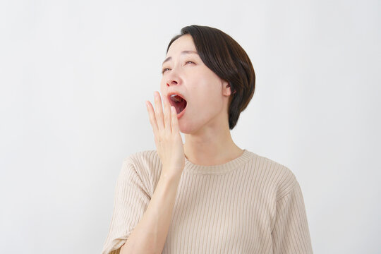 あくびをする女性　ミドルエイジ　白背景