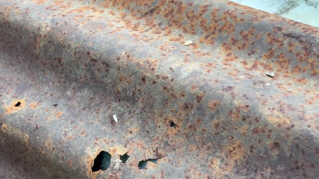 Industrial footage of old rusty corrugated zinc sheet with orange oxidized texture and wavy surface